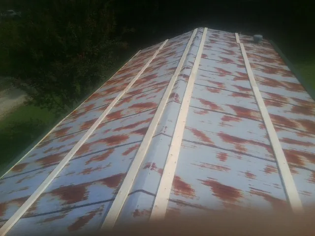 Rusted metal roof panels with new wood purlins before replacement — Storm Damage Roof Repair in Chickasha by Roofing Brothers