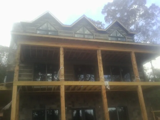 Dormers and porch framing on a large log home under construction — Roof Coating work by our crew in Chickasha