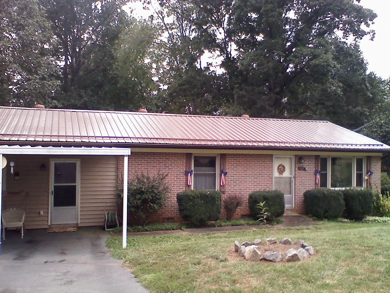 Bronze metal roof and carport on a brick ranch home — Roof Repair work by our crew in Chickasha
