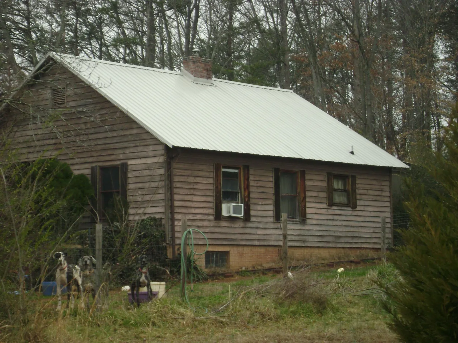 White metal roof on an old wood sided farmhouse, from a Metal Roof Installation job in Chickasha